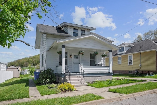bungalow featuring a porch and a front lawn