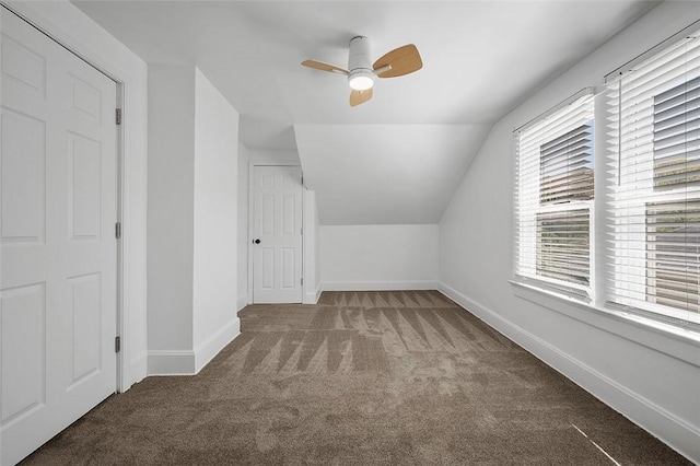 additional living space featuring vaulted ceiling, carpet flooring, baseboards, and a ceiling fan