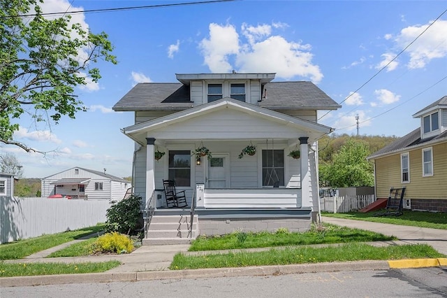 view of front of house featuring a porch and fence