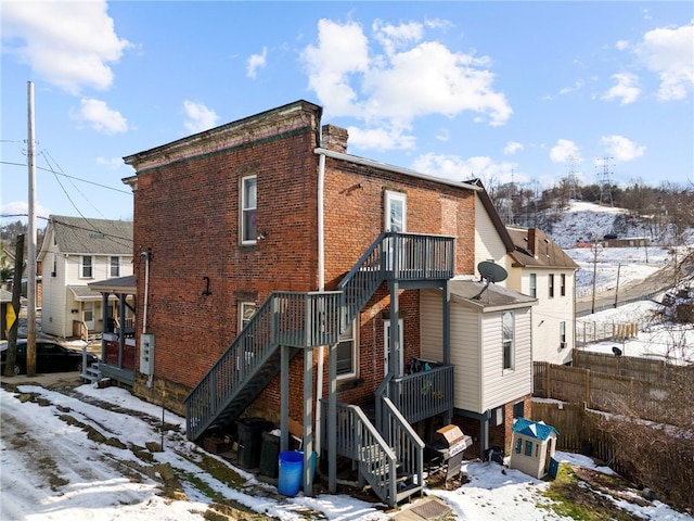 209-211 S Wade St, City Of Washington, PA 15301 - snow covered back of property with stairs, brick siding, and fence