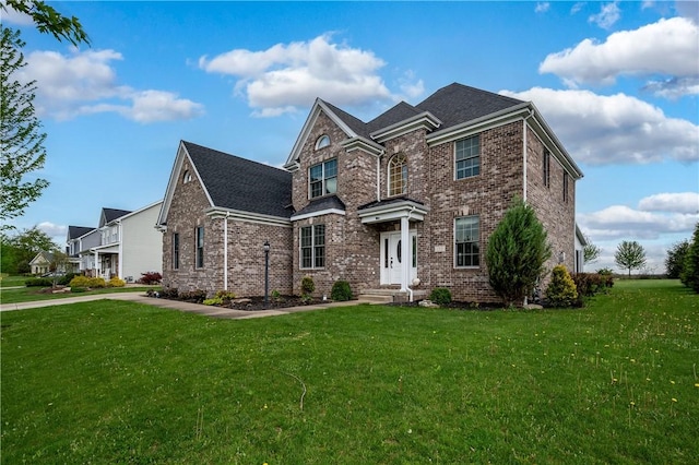 view of front facade with a front yard and brick siding