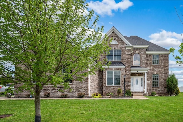 traditional home featuring brick siding and a front lawn