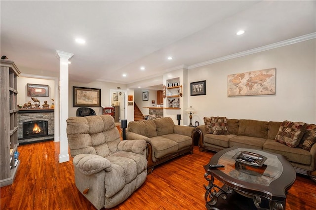 living area with wood finished floors, recessed lighting, decorative columns, ornamental molding, and stairs