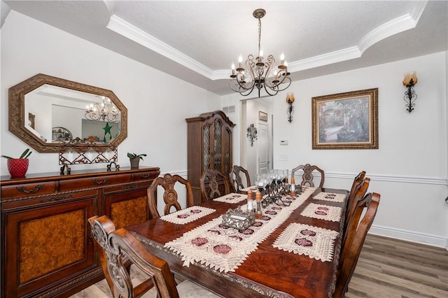 dining area with crown molding, a notable chandelier, and wood finished floors