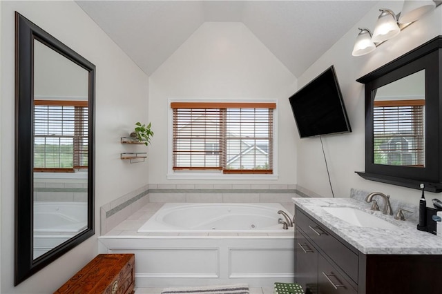 full bath with vanity, a whirlpool tub, and lofted ceiling