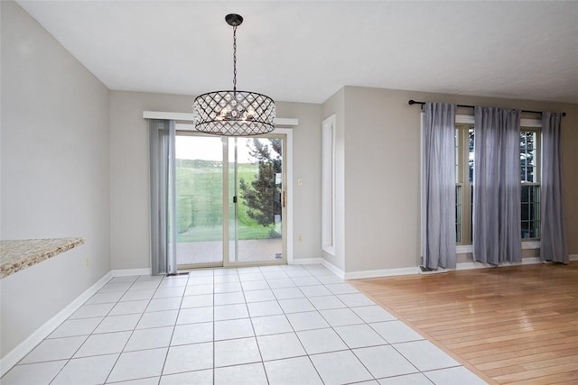 1004 Augusta Ln, Penn Twp Wml, PA 15644 - unfurnished dining area featuring a chandelier, baseboards, and light wood-type flooring