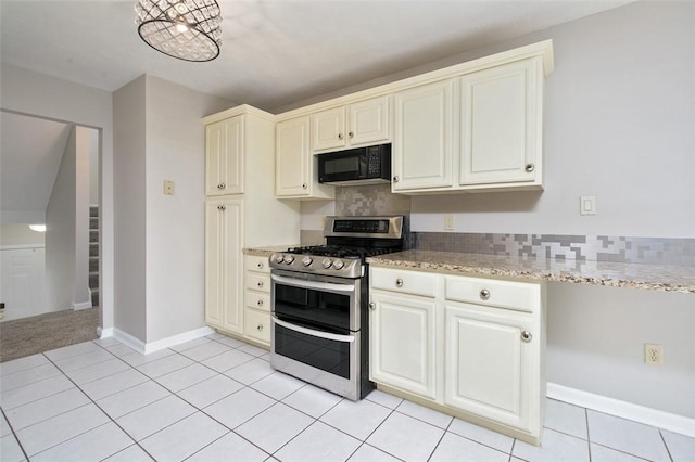 1004 Augusta Ln, Penn Twp Wml, PA 15644 - kitchen with range with two ovens, black microwave, light tile patterned flooring, light stone countertops, and cream cabinetry
