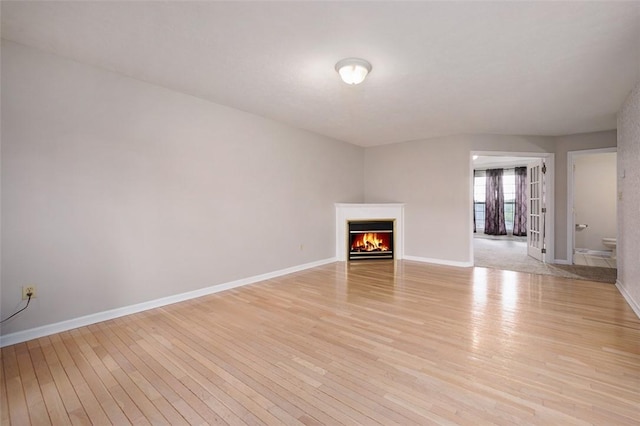 1004 Augusta Ln, Penn Twp Wml, PA 15644 - unfurnished living room with light wood finished floors, baseboards, and a warm lit fireplace