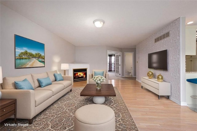 1004 Augusta Ln, Penn Twp Wml, PA 15644 - living room featuring light wood finished floors, baseboards, and a lit fireplace