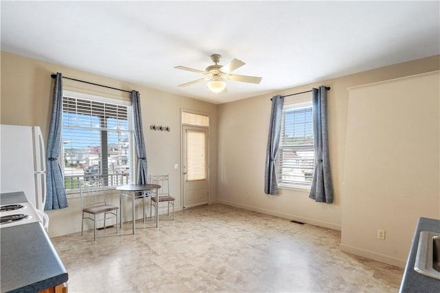 unfurnished dining area with visible vents, baseboards, ceiling fan, and a sink