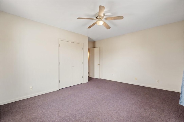 unfurnished bedroom featuring ceiling fan, a closet, baseboards, and dark carpet