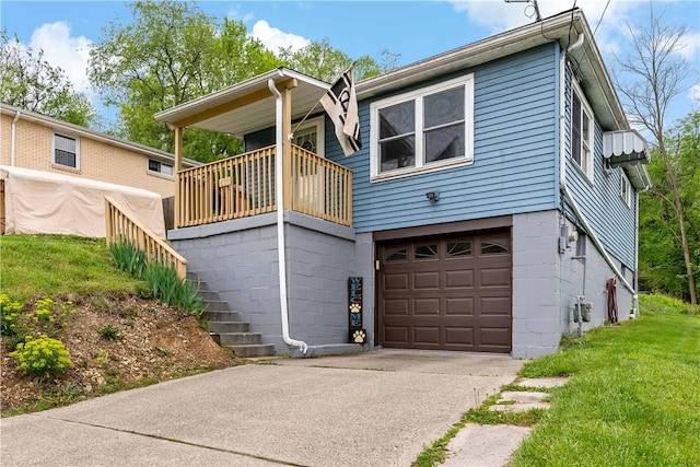 back of house featuring concrete driveway, a yard, and a garage