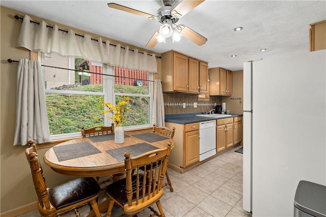 kitchen featuring white dishwasher, tasteful backsplash, ceiling fan, and plenty of natural light