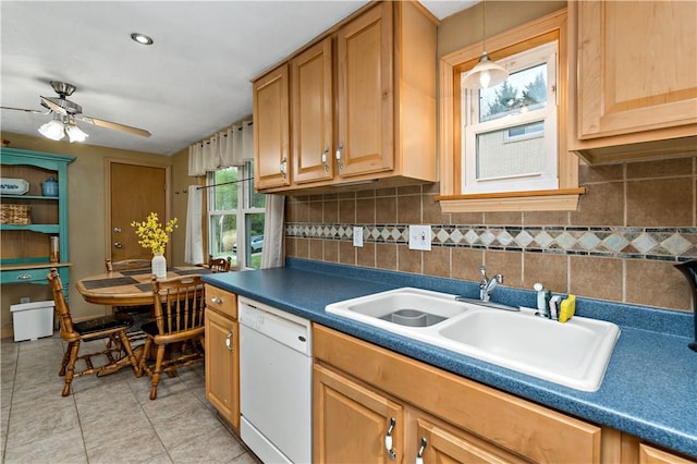 kitchen featuring white dishwasher, ceiling fan, a sink, decorative backsplash, and dark countertops