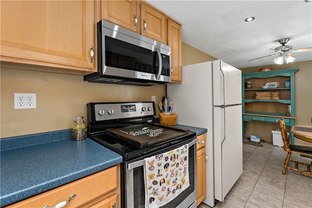 kitchen featuring light tile patterned floors, appliances with stainless steel finishes, a ceiling fan, and dark countertops
