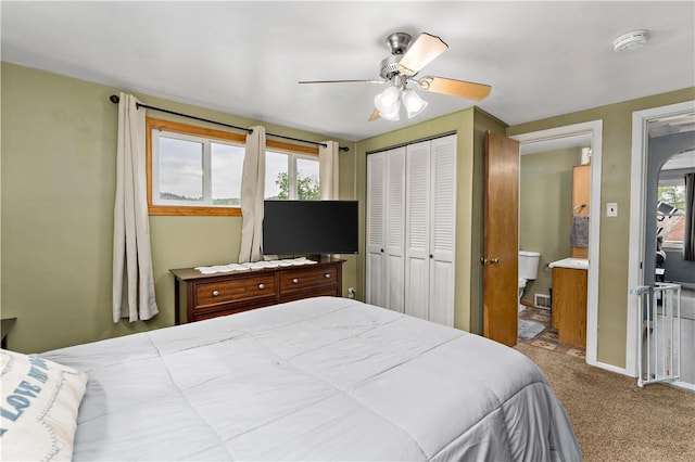 bedroom featuring ensuite bathroom, a closet, ceiling fan, carpet flooring, and baseboards
