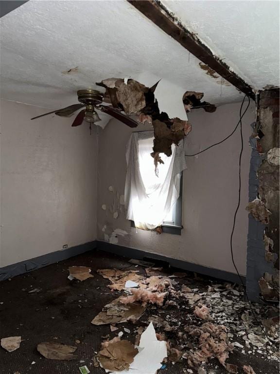 spare room with a ceiling fan and a textured ceiling