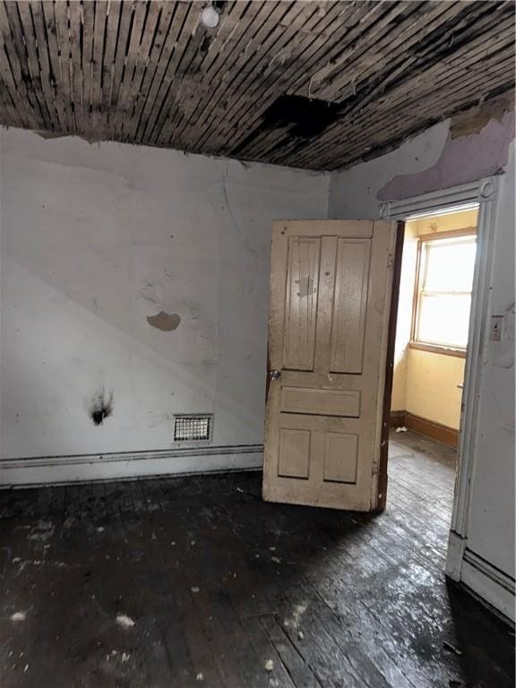 spare room featuring hardwood / wood-style floors and baseboards