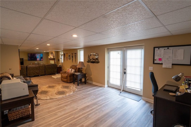 living room featuring a paneled ceiling, wood finished floors, baseboards, a desk, and french doors