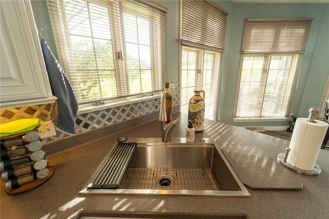 kitchen view of a sink and white cabinets