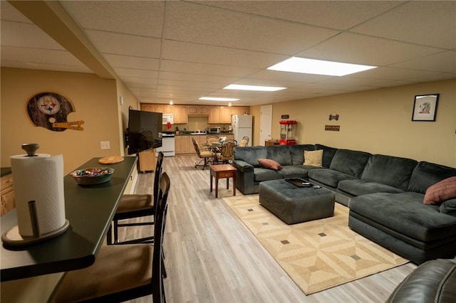 living room with light wood-style floors and a drop ceiling