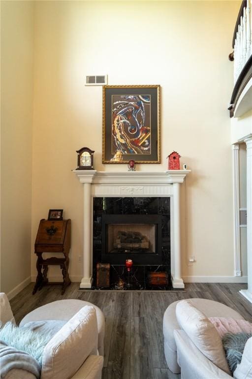 living area featuring wood finished floors, a premium fireplace, and baseboards