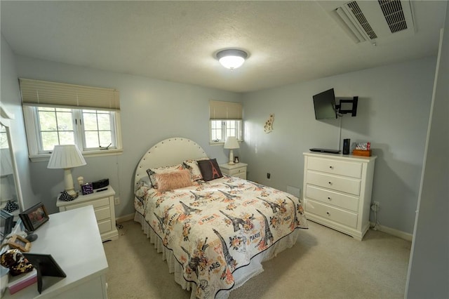 bedroom featuring light carpet, multiple windows, and baseboards