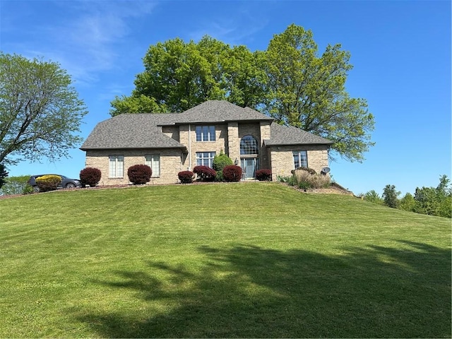 view of front of property with a front lawn and roof with shingles