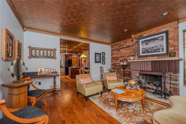 2220 Sarah St, South Side, PA 15203 - living area featuring wood-type flooring, ornamental molding, a brick fireplace, and brick wall