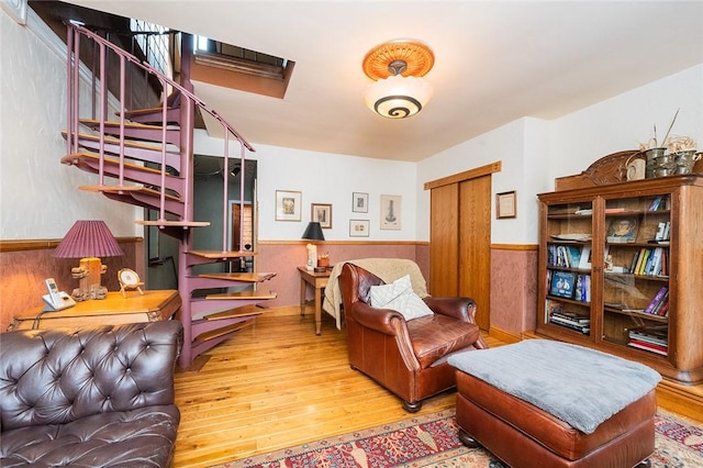 2220 Sarah St, South Side, PA 15203 - living area featuring wood finished floors, a wainscoted wall, and stairs