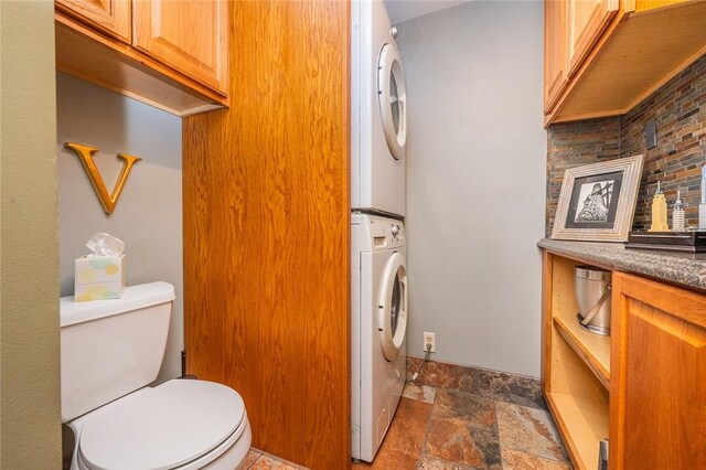 2220 Sarah St, South Side, PA 15203 - bathroom featuring stacked washer / drying machine, stone tile flooring, and toilet