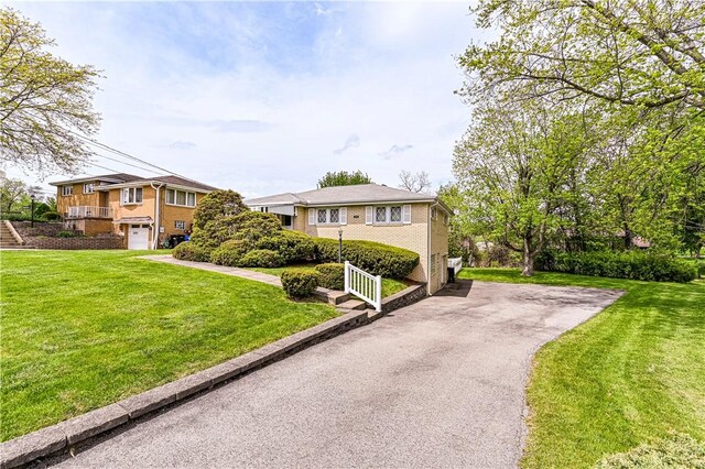 1079 Hedy Lynn Dr, North Huntingdon, PA 15642 - view of front of home featuring asphalt driveway, an attached garage, and a front yard