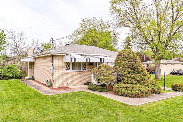 1079 Hedy Lynn Dr, North Huntingdon, PA 15642 - back of house with a chimney, brick siding, a lawn, and roof with shingles