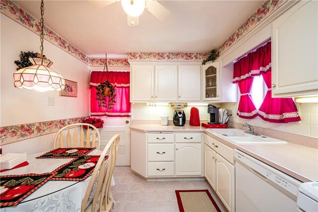 1079 Hedy Lynn Dr, North Huntingdon, PA 15642 - kitchen with white dishwasher, a sink, light countertops, glass insert cabinets, and white cabinets