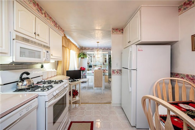 1079 Hedy Lynn Dr, North Huntingdon, PA 15642 - kitchen with white appliances, a chandelier, light countertops, white cabinetry, and hanging light fixtures