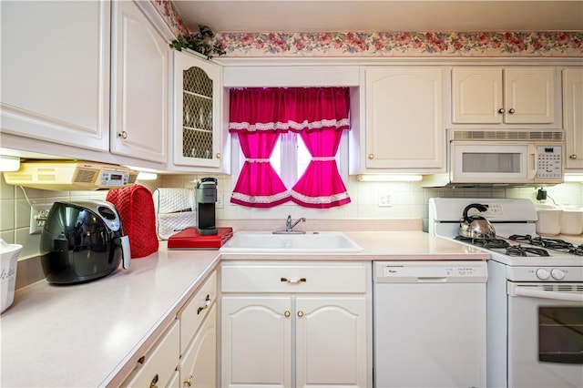 1079 Hedy Lynn Dr, North Huntingdon, PA 15642 - kitchen with white appliances, a sink, decorative backsplash, light countertops, and glass insert cabinets