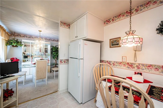 1079 Hedy Lynn Dr, North Huntingdon, PA 15642 - kitchen with freestanding refrigerator, a chandelier, white cabinetry, decorative light fixtures, and light colored carpet