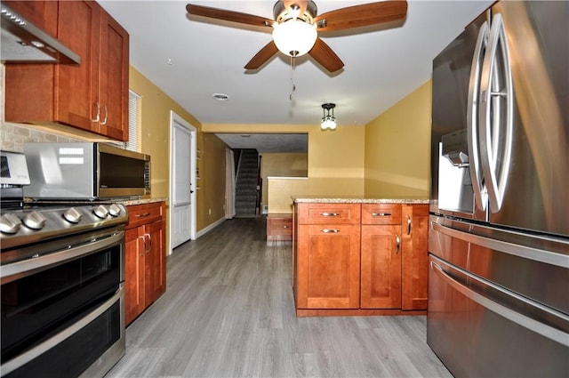 3053 Scheinbach Rd, Jefferson Hills, PA 15332 - kitchen with appliances with stainless steel finishes, under cabinet range hood, light wood-type flooring, a peninsula, and brown cabinetry
