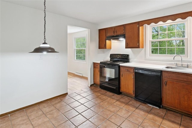179 Kelvington Dr, Monroeville, PA 15146 - kitchen with black appliances, a sink, under cabinet range hood, light countertops, and brown cabinetry