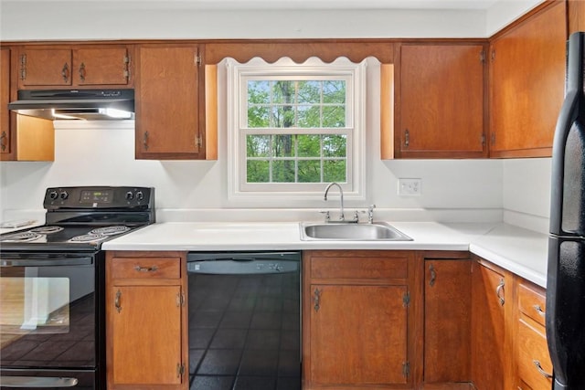 179 Kelvington Dr, Monroeville, PA 15146 - kitchen featuring black appliances, under cabinet range hood, a sink, light countertops, and brown cabinets