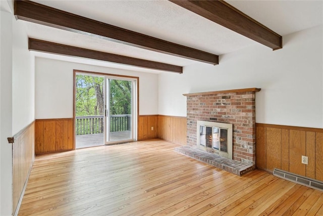 179 Kelvington Dr, Monroeville, PA 15146 - unfurnished living room featuring a wainscoted wall, wooden walls, hardwood / wood-style flooring, a fireplace, and beam ceiling