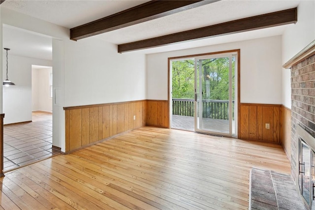 179 Kelvington Dr, Monroeville, PA 15146 - spare room with wooden walls, a wainscoted wall, hardwood / wood-style flooring, a fireplace, and beam ceiling