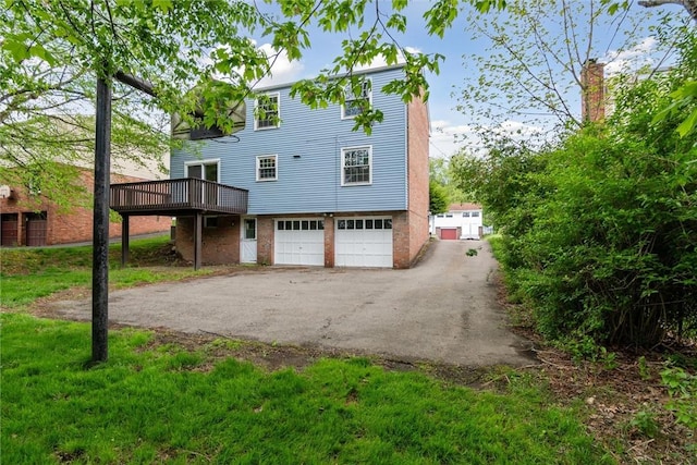 179 Kelvington Dr, Monroeville, PA 15146 - rear view of house featuring an attached garage, a wooden deck, and asphalt driveway