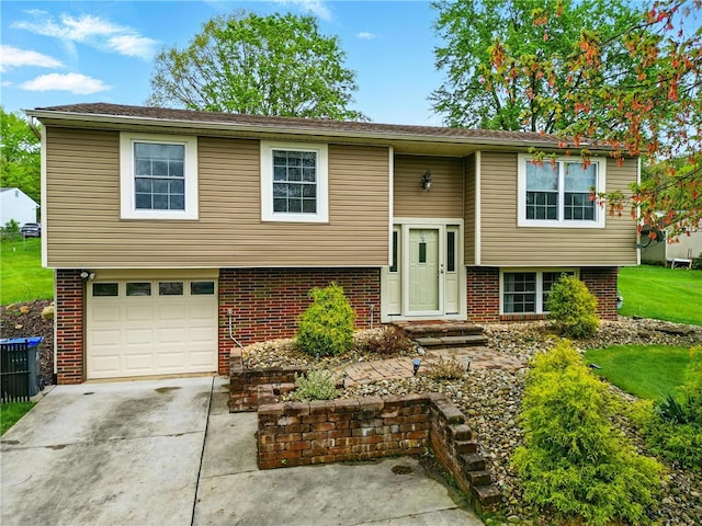 raised ranch with an attached garage, central AC, brick siding, and driveway