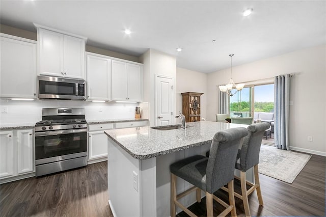 7005 Augusta Ln, Penn Twp Wml, PA 15644 - kitchen with stainless steel appliances, dark wood-style floors, a sink, white cabinets, and light stone countertops