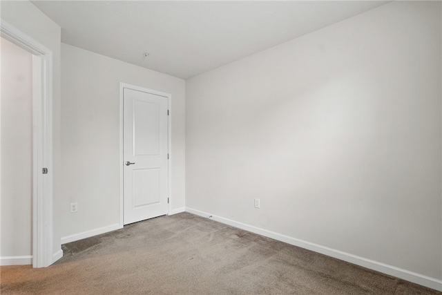 unfurnished room featuring carpet flooring and baseboards