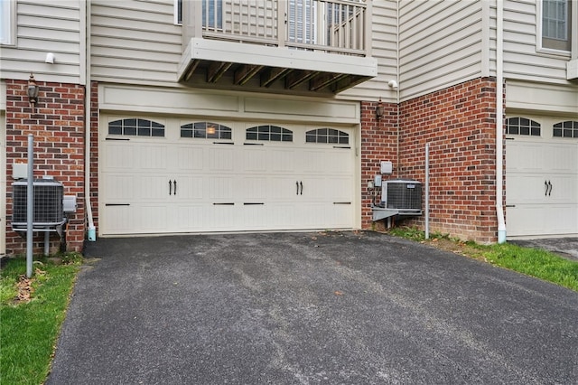 garage with asphalt driveway and cooling unit