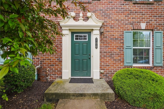 doorway to property featuring brick siding