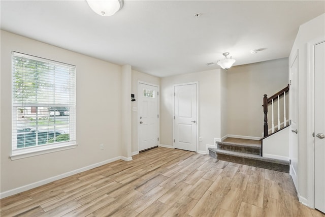 foyer entrance featuring plenty of natural light, stairway, and light wood finished floors