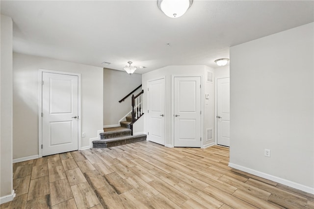 basement with light wood-style floors, stairs, and baseboards